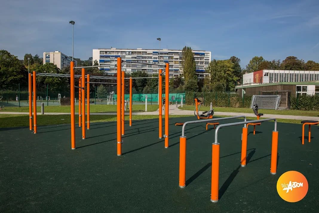 parc-fitness-ville-davray-vue-ensemble Équipement sportif urbain avec agrès de street workout, à proximité d'un immeuble et de courts de tennis